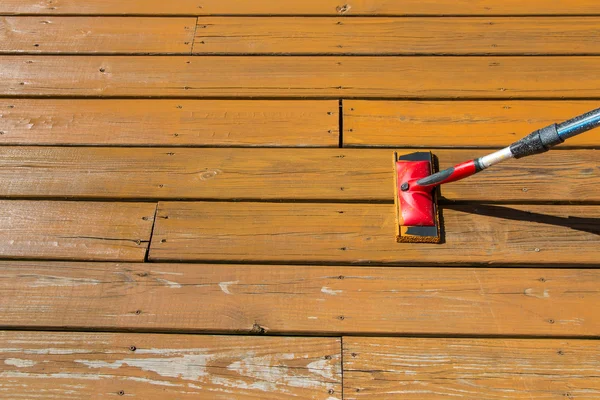 Mancha de madera con una almohadilla de pintura en el suelo del patio de madera —  Fotos de Stock