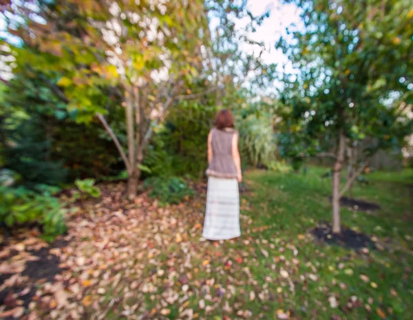 Silhouette of a woman in blurred defocused garden