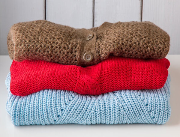 Stack of women's sweaters and cardigans.