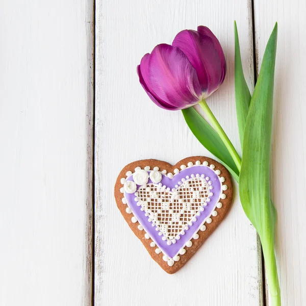 Biscotto a forma di cuore decorato con ornamenti e fiori . Immagine Stock