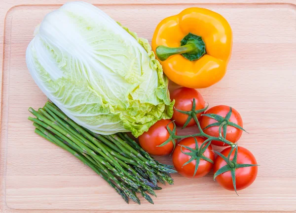 Verduras frescas en tabla de cortar de madera — Foto de Stock