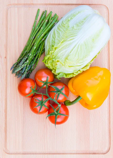 Verduras frescas en tabla de cortar de madera, comida saludable . — Foto de Stock