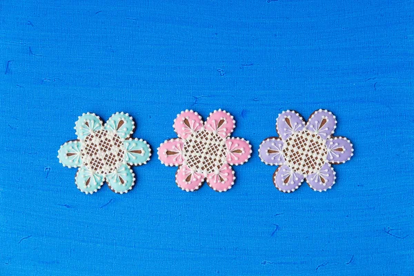 Flores en forma de galletas decoradas con adornos sobre fondo azul — Foto de Stock