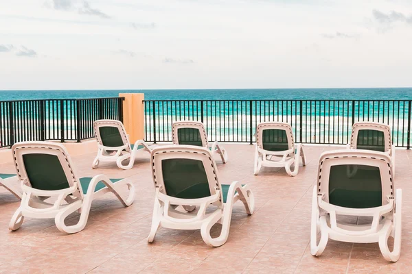Chaise-longue vacío para tomar el sol en el patio cerca de la playa del océano —  Fotos de Stock