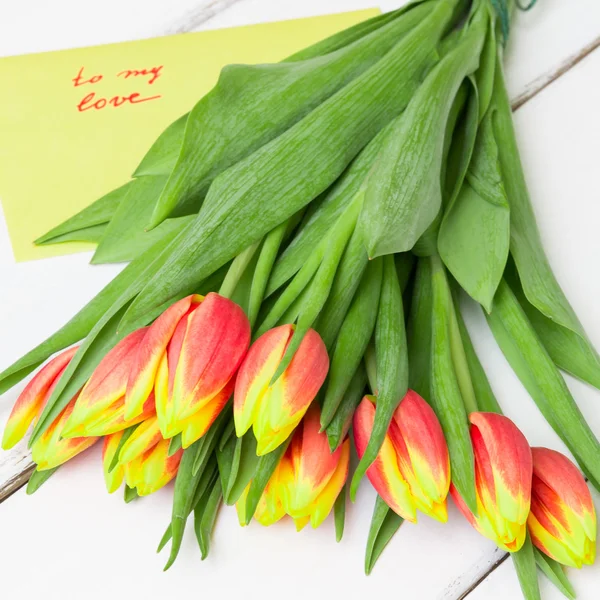 Ramo de tulipanes rojos amarillos sobre fondo de madera —  Fotos de Stock