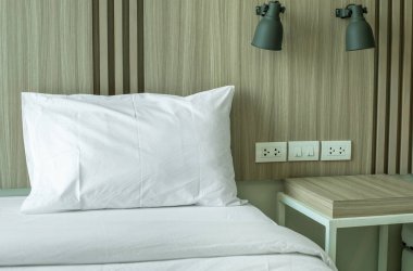 Modern yatak odası, içinde lamba ve masa var. 