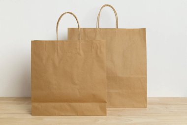 Boş şablon için ahşap masada iki kahverengi kese.