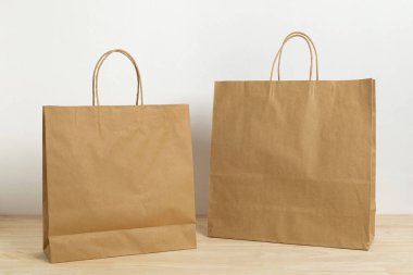 Boş şablon için ahşap masada iki kahverengi kese.