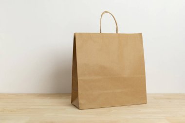 Boş şablon için ahşap masa üzerinde kahverengi kağıt çanta