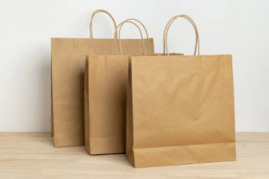 three brown paper bag on wooden table for mockup blank template