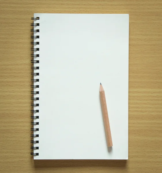 Cuaderno en espiral en blanco y lápiz sobre fondo de madera — Foto de Stock