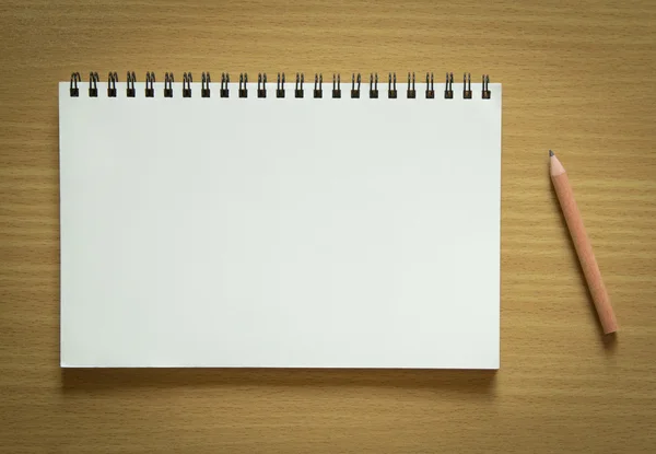 Cuaderno en espiral en blanco y lápiz sobre fondo de madera —  Fotos de Stock