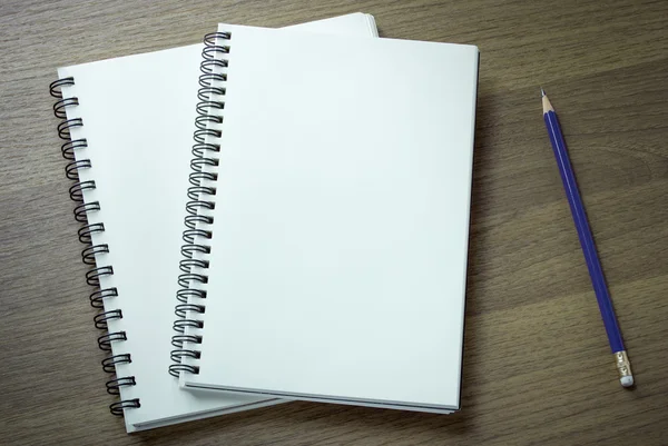 Cuaderno en espiral en blanco y lápiz sobre fondo de madera oscura —  Fotos de Stock
