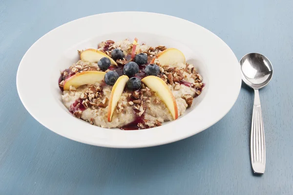 Harina de avena con manzanas, bayas negras, frutos secos y cobertura — Foto de Stock