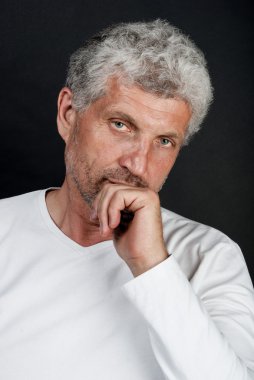 Siyah bir arka plan gri saçlı orta yaşlı bir adam portresi
