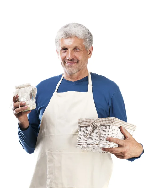 O homem em um avental prepara a comida em um fundo branco — Fotografia de Stock