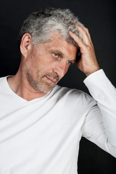 Portrait of a gray-haired middle-aged man on a black background — Stock Photo, Image