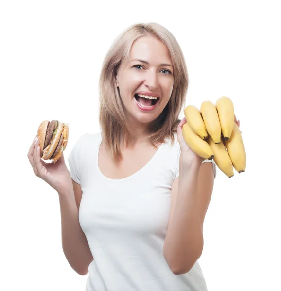 Mulher faz a escolha de hambúrguer e bananas Fotos De Bancos De Imagens Sem Royalties