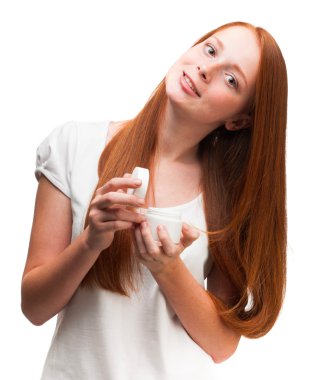 yüz kremi paketiyle tutan genç kırmızı saçlı kız. Isola