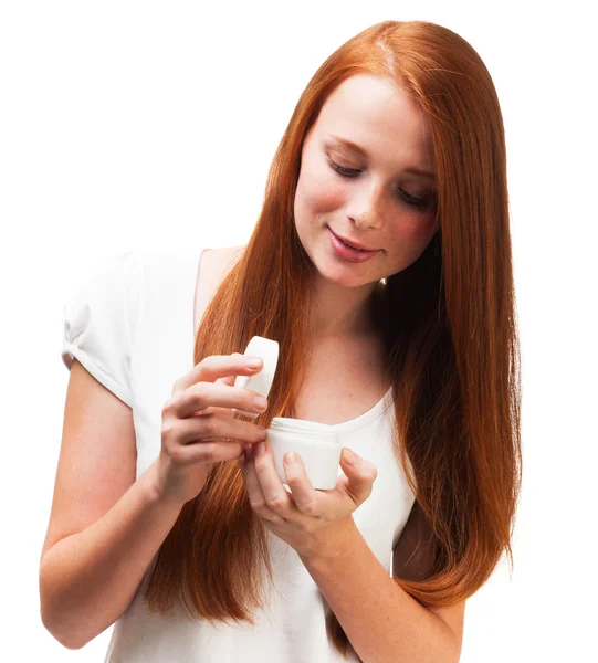 Young red-haired girl holding a package with a face cream. Isola — Stock Photo, Image