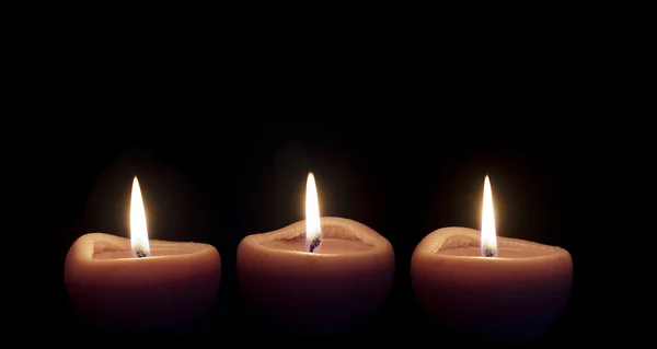 Свічки, що освітлюють у темряві — стокове фото