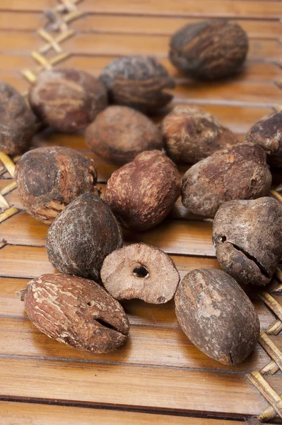 Nueces de karité cerca de mantequilla sobre fondo blanco — Foto de Stock