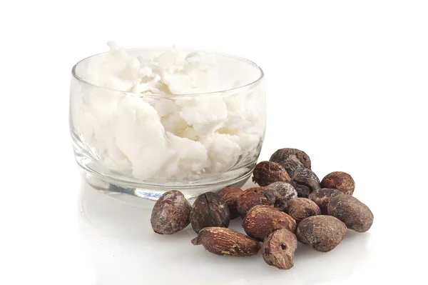 Shea nuts near butter on white background — Stock Photo, Image