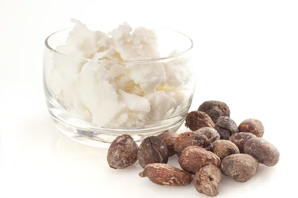 Shea nuts near butter on white background — Stock Photo, Image