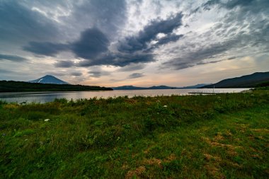 Petropavlovsk-Kamçatsky kentinin panoramik manzarası ve volkanlar: Koryaksky Volkanı, Avacha Volkanı, Kozelsky Volkanı. Rus Uzak Doğusu, Kamçatka Yarımadası.