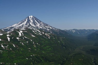 Petropavlovsk-Kamçatsky kentinin panoramik manzarası ve volkanlar: Koryaksky Volkanı, Avacha Volkanı, Kozelsky Volkanı. Rus Uzak Doğusu, Kamçatka Yarımadası.