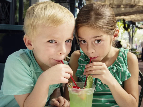 Lindos niños compartiendo una bebida julep menta — Foto de Stock