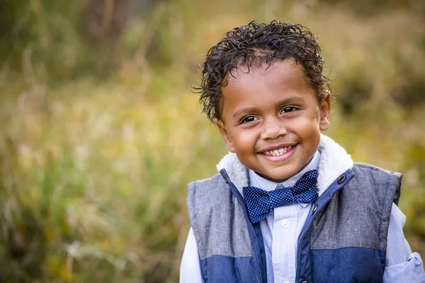 Söta utomhus porträtt av en leende African American ung pojke. — Stockfoto