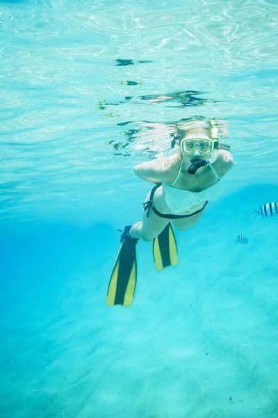 Retrato submarino de una mujer haciendo snorkel en un mar tropical claro — Foto de Stock