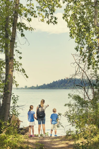 Family near a beautiful mountain lake. — Stock Photo, Image