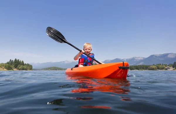Jeune garçon pagayant un kayak — Photo