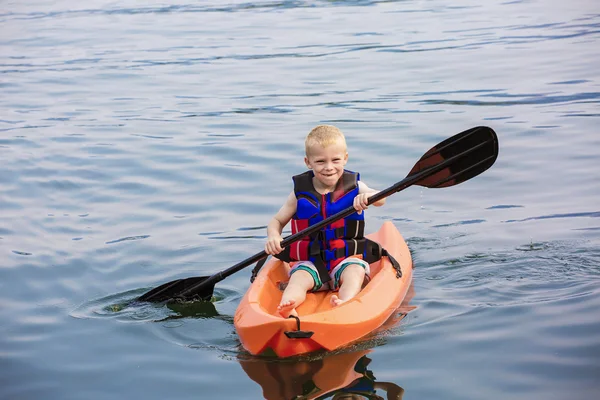 Jonge jongen een kajak peddelen — Stockfoto