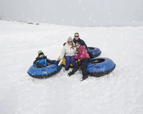 Eine Familie beim Schneeschlittenfahren — Stockfoto