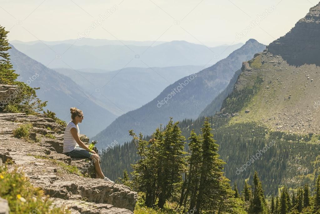 A woman sitting on a rocky ledge