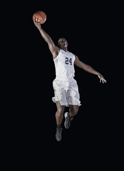 Jogador de basquete marcando um cesto. Saltando alto e fazendo um layup . — Fotografia de Stock