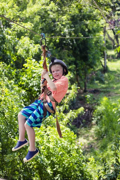 Ragazzo cavalcando una zip line — Foto Stock