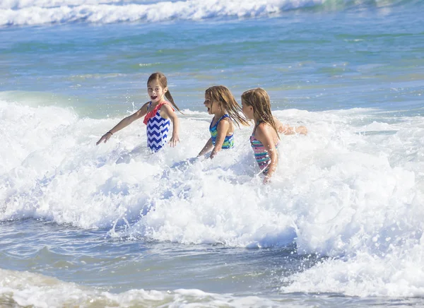 Crianças brincando no oceano surf — Fotografia de Stock