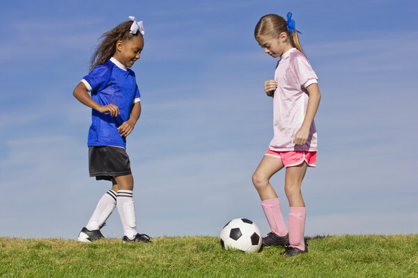 Две молодые девушки играют в футбол
