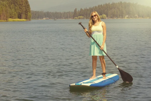 Bella donna paddleboarding sul lago panoramico — Foto Stock