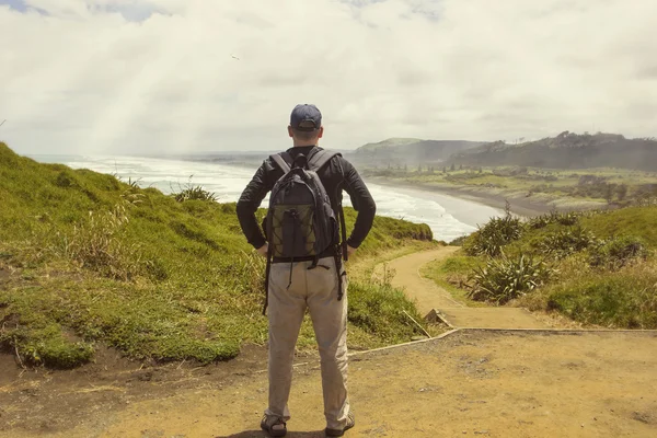 Male hiker looking at a beautiful ocean — Stock Photo, Image