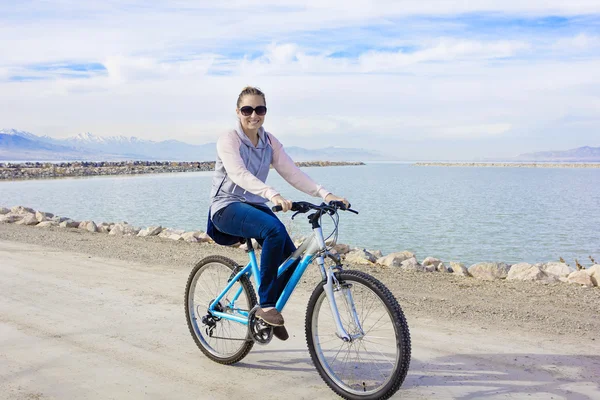 Mulher de bicicleta ao longo da orla — Fotografia de Stock