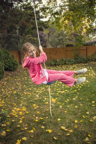 Girl riding rope swing — Stock Photo, Image
