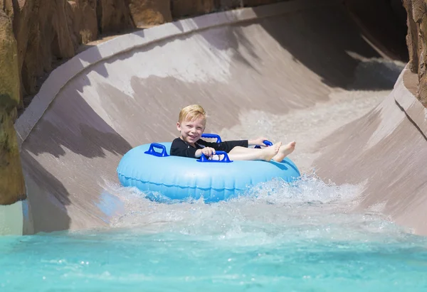 Menino desfrutando de slide de água — Fotografia de Stock