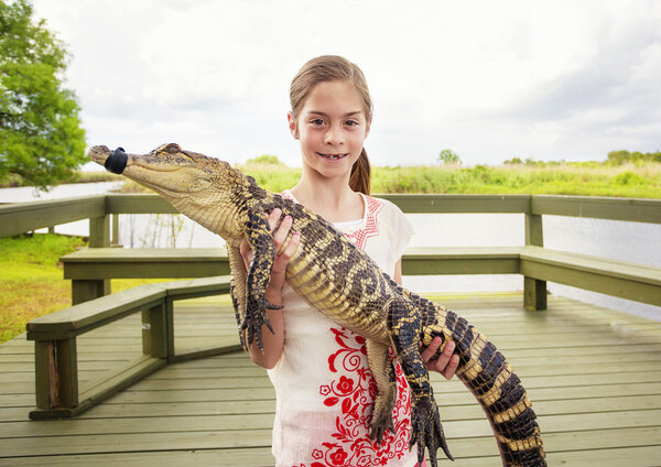 girl holding a crocodile