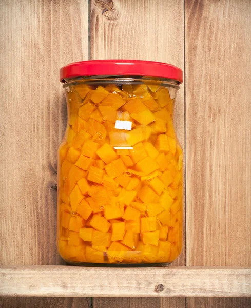 Preserved  carrots on shelf near a brown wooden wall — Stock Photo, Image