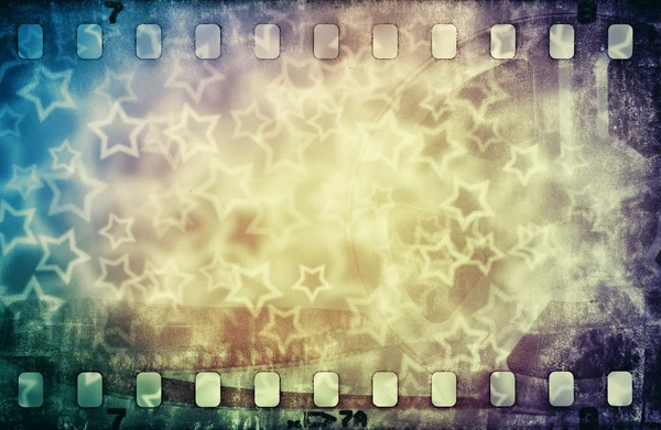 Grunge scratched colorful film strip with stars background — Stock Photo, Image